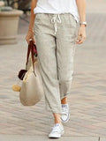 Pantalon lin beige femme, style décontracté avec top blanc et baskets, idéal pour look bohème ou quotidien