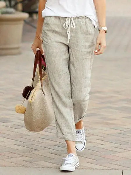 Pantalon lin beige femme, style décontracté avec top blanc et baskets, idéal pour look bohème ou quotidien