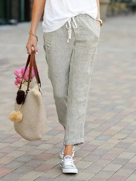 Pantalon lin beige femme, sac paille et baskets blanches, look été mode féminine