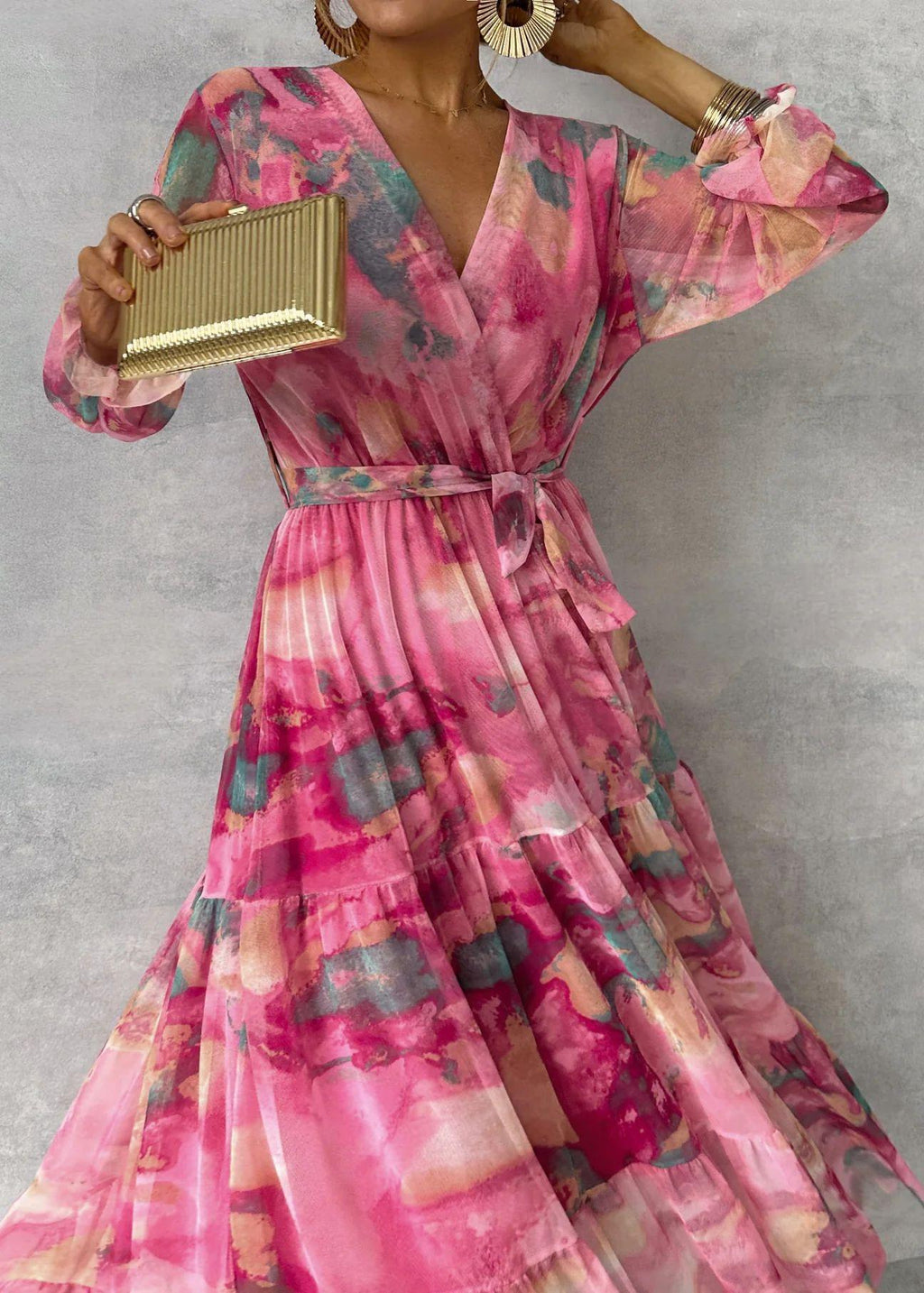 Robe féminine imprimée rose à manches volants, ceinture nouée, sac doré et boucles d'oreilles
