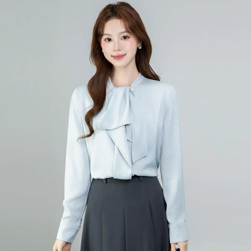 Blouse féminine bleu clair à nœud, manches longues, style élégant et moderne pour tenue de bureau
