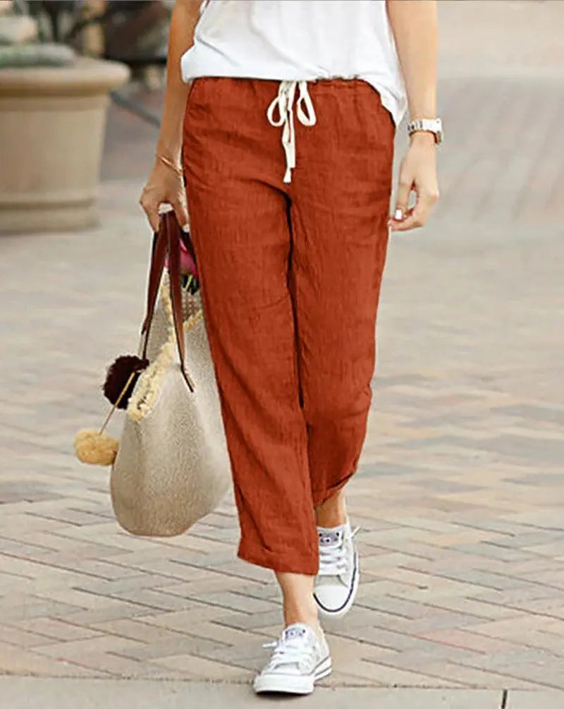 Pantalon lin marron femme, style bohème, avec top blanc et baskets, idéal pour look décontracté