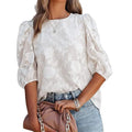 Blouse féminine blanche à manches bouffantes et motifs floraux, idéale pour un look bohème élégant