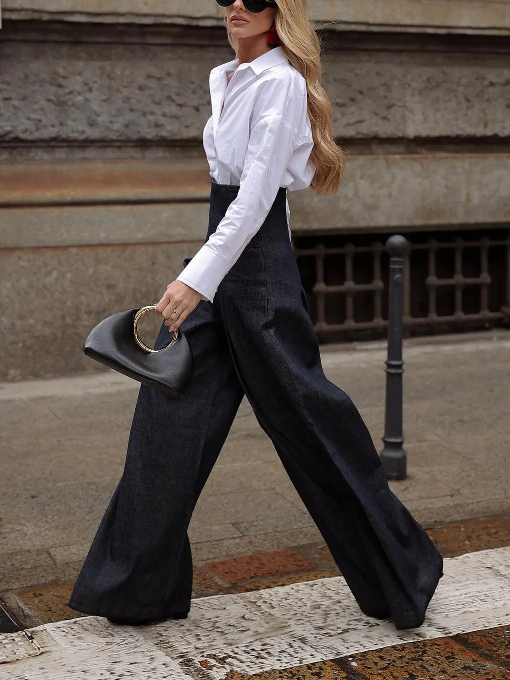 Femme en pantalon large bleu marine et chemise blanche, style mode féminine élégante