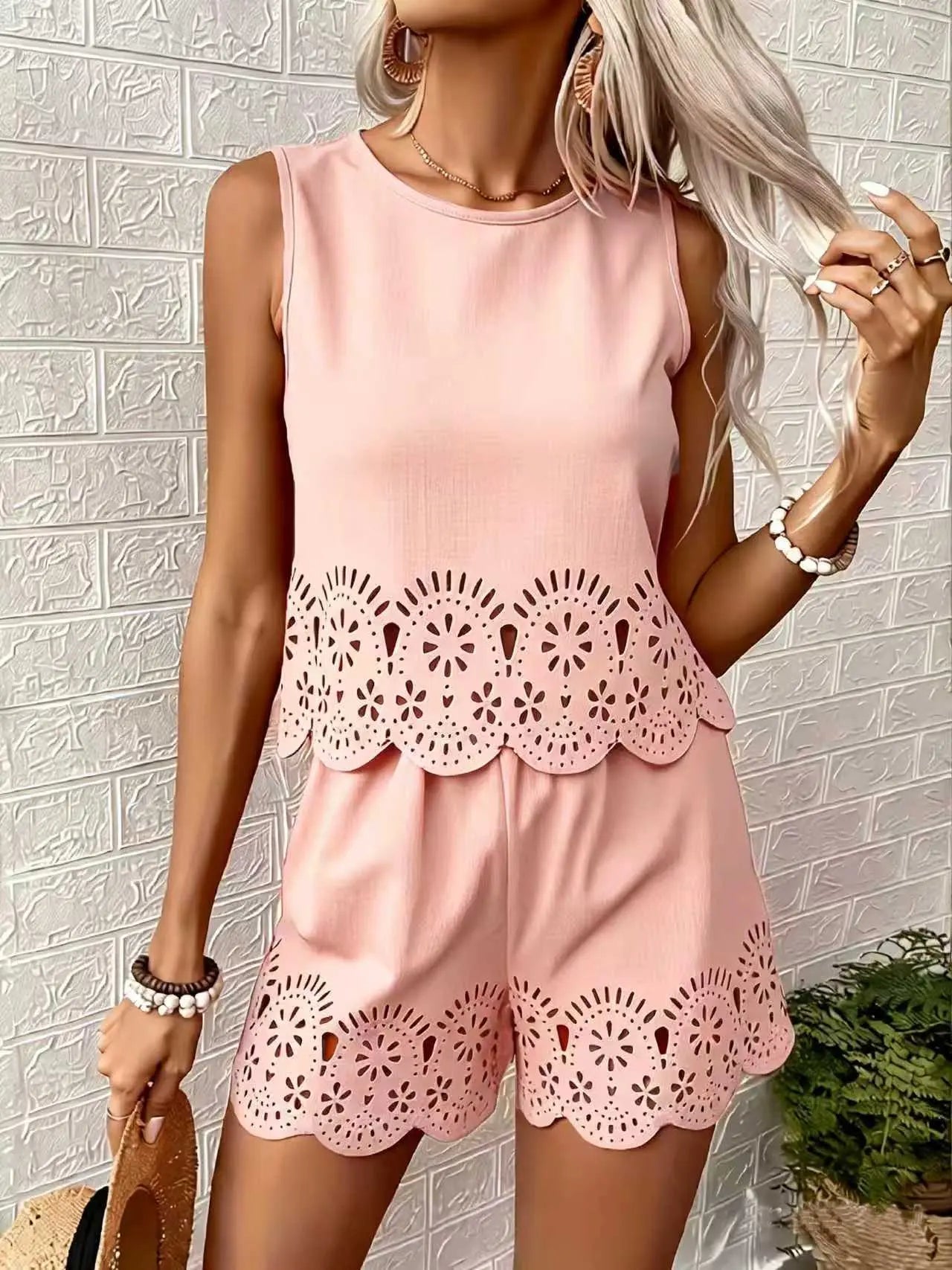 Tenue féminine rose pâle avec découpes florales et bordure ondulée, idéale pour l'été