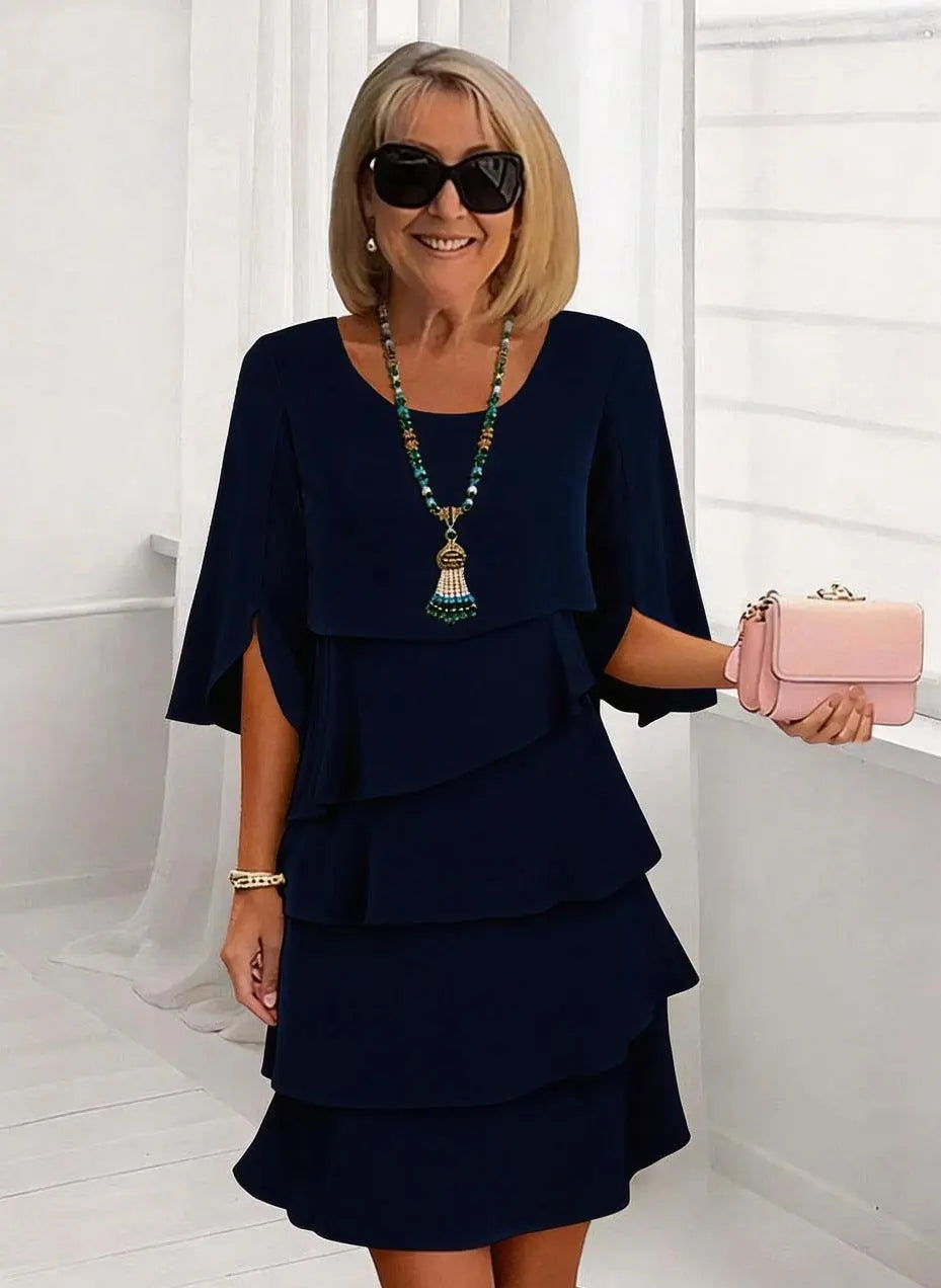Robe féminine bleu marine à volants, style élégant avec sac rose et bijoux, idéale pour toutes occasions
