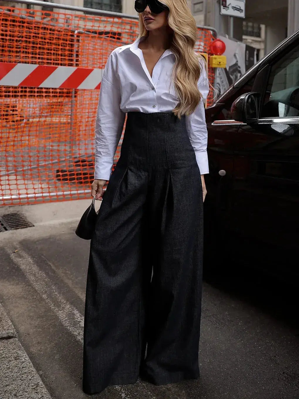 Femme en chemise blanche et pantalon large noir, style mode féminine urbaine