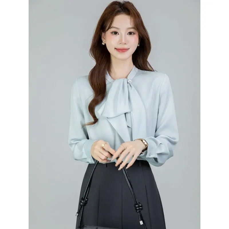 Blouse féminine bleu clair à nœud et manches longues, style élégant pour tenue de bureau