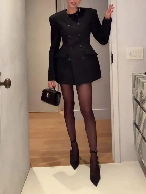 Robe noire structurée à manches longues, talons aiguilles et sac à main pour look élégant féminin