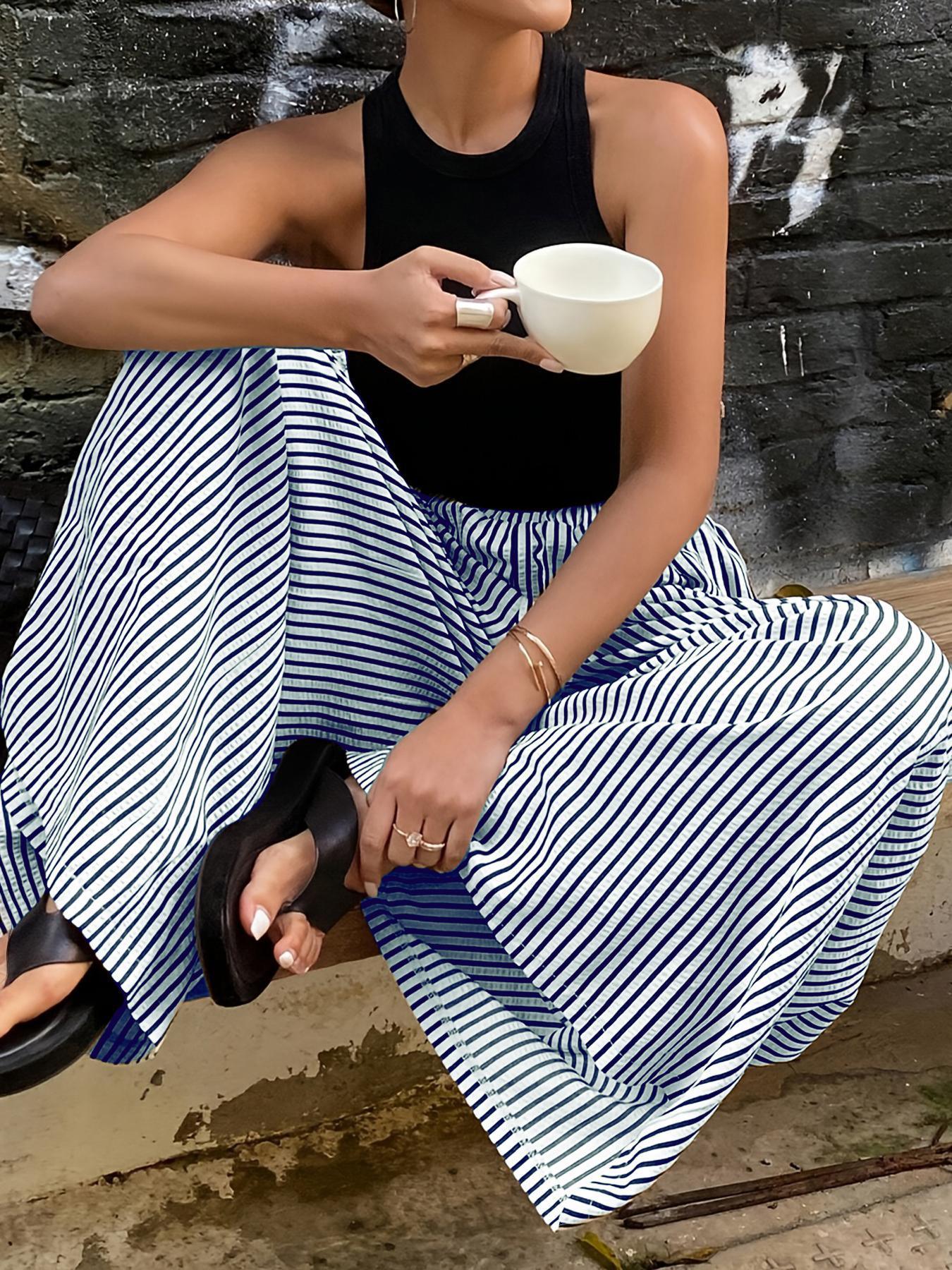 Femme en jupe large rayée bleu blanc et top noir, tenue mode féminine décontractée